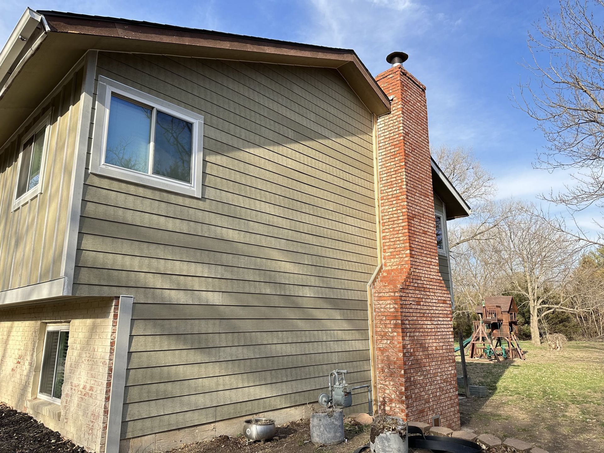 A house with a brick chimney on the side of it.