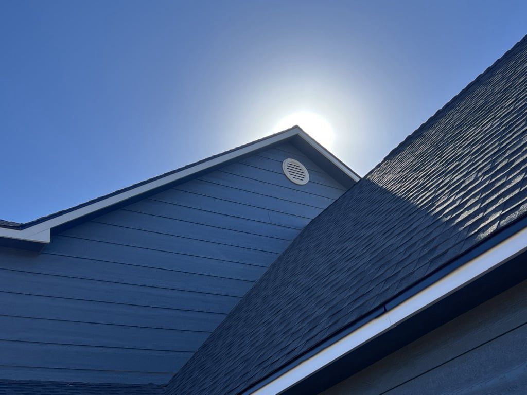 The sun is shining on the roof of a house