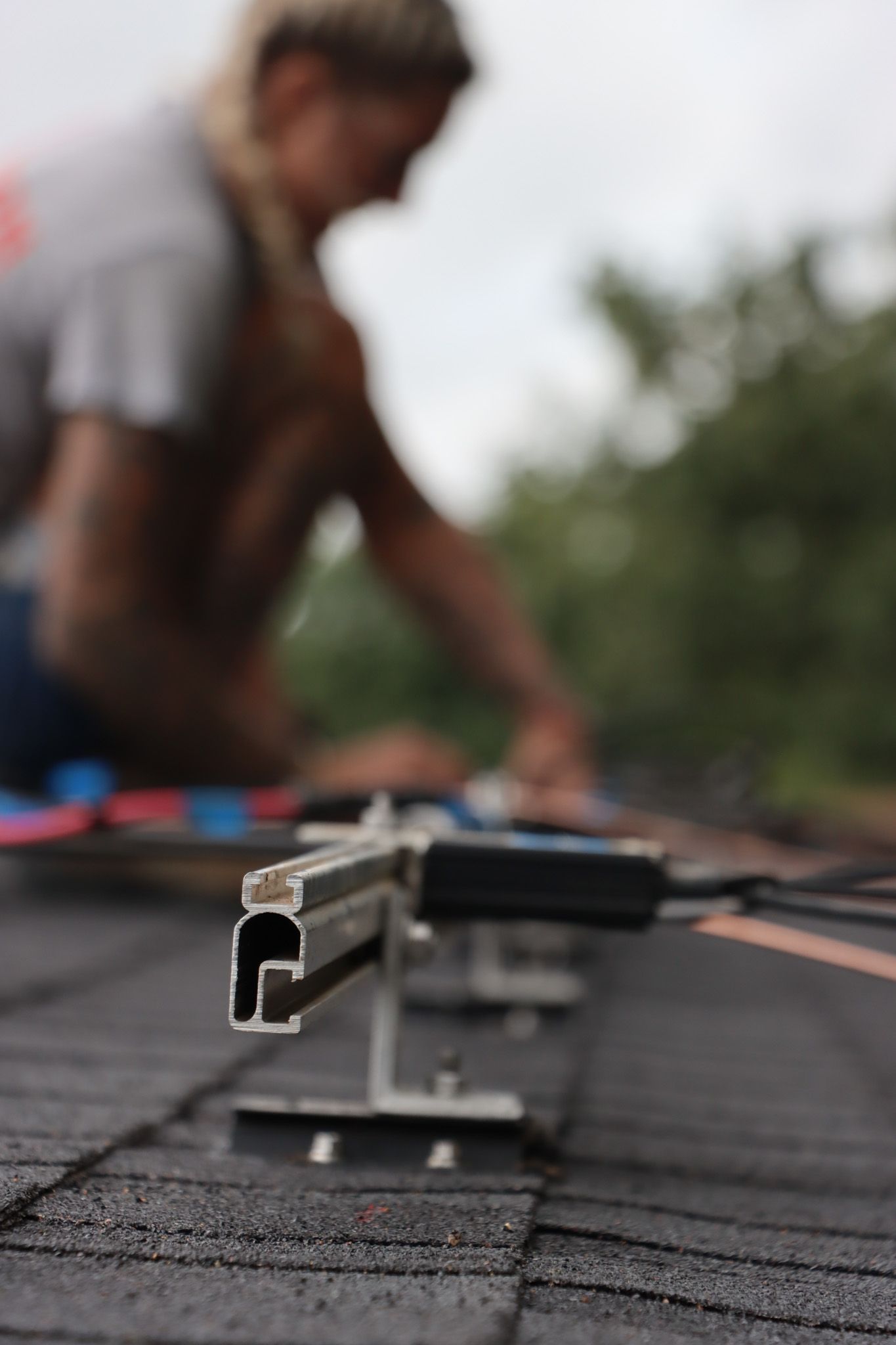 A woman is working on a solar panel on a roof