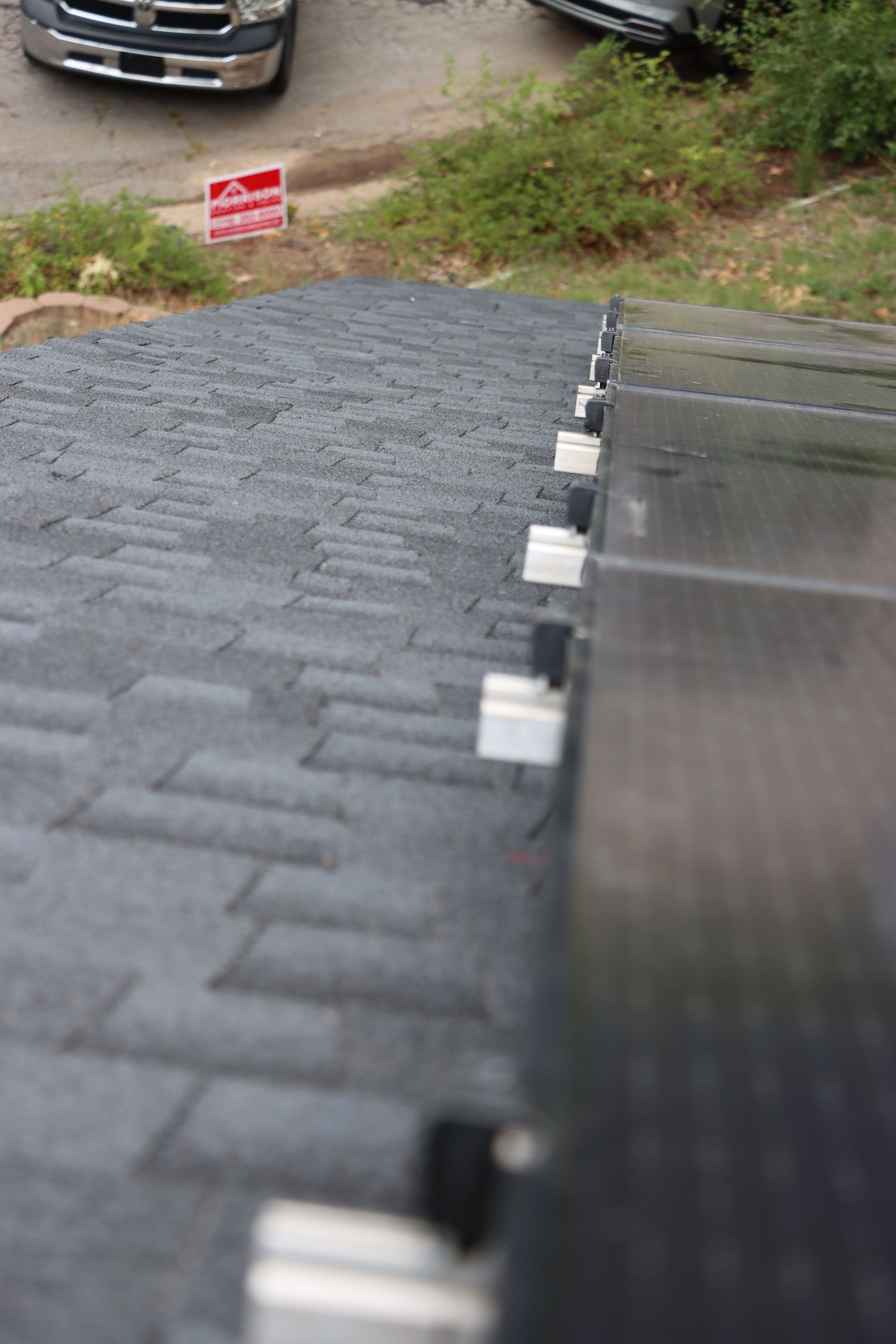 A close up of a roof with a car parked in the background.