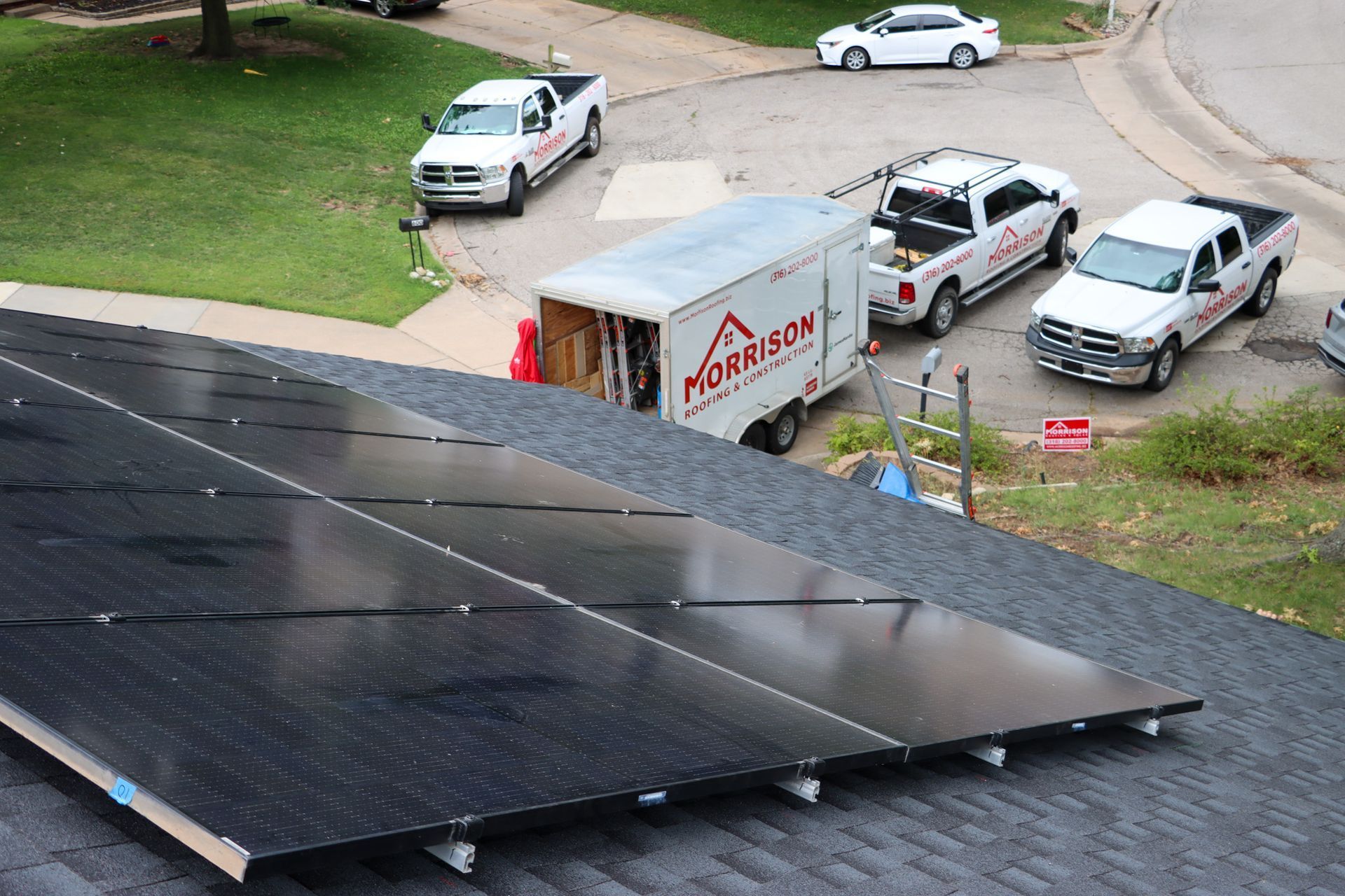 A row of solar panels are sitting on top of a roof.