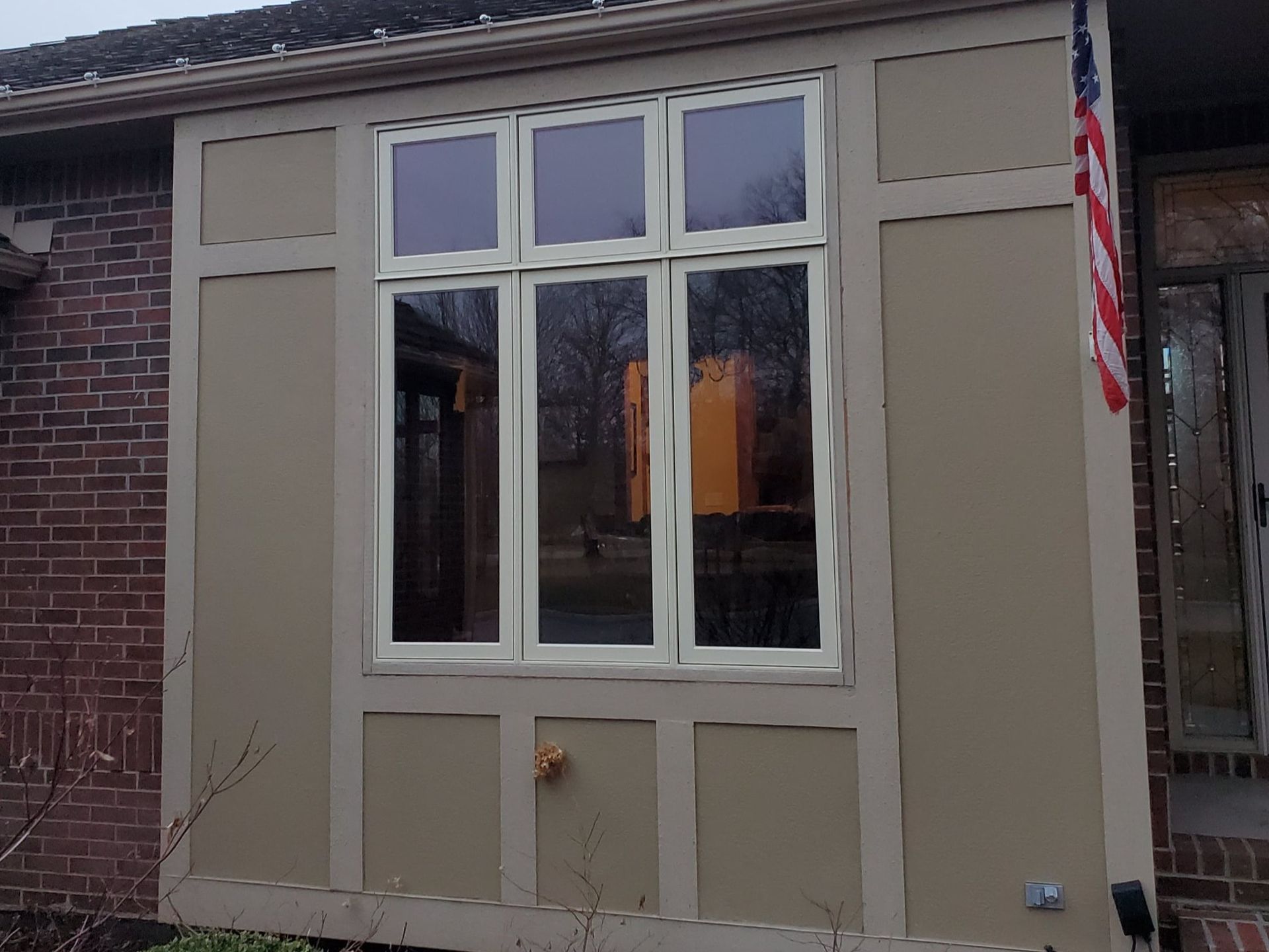 A large window on the side of a brick house