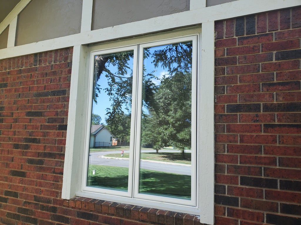 A brick wall with a white window on it