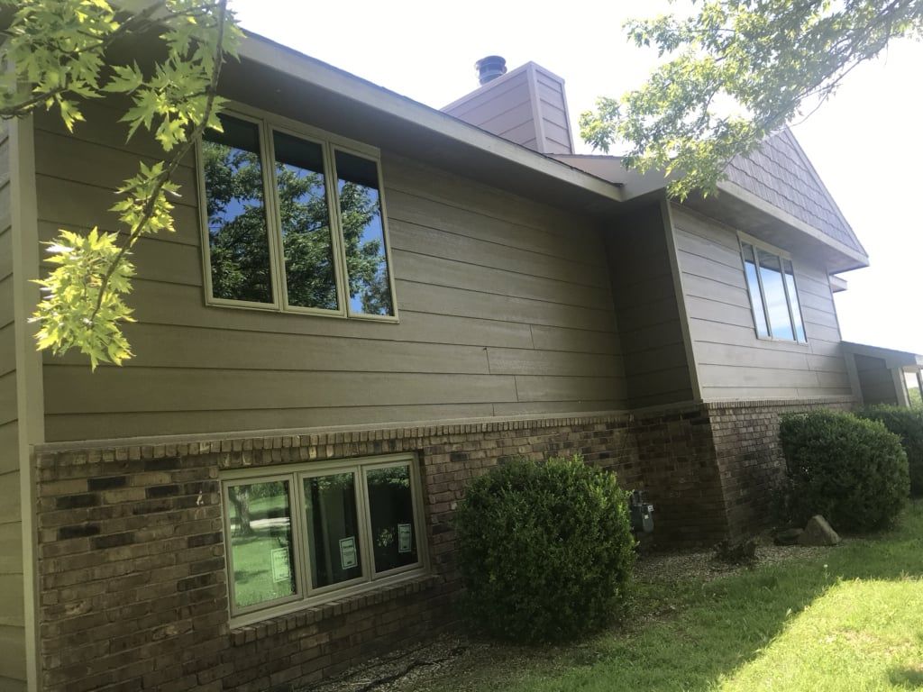 A large house with a lot of windows and a brick wall.