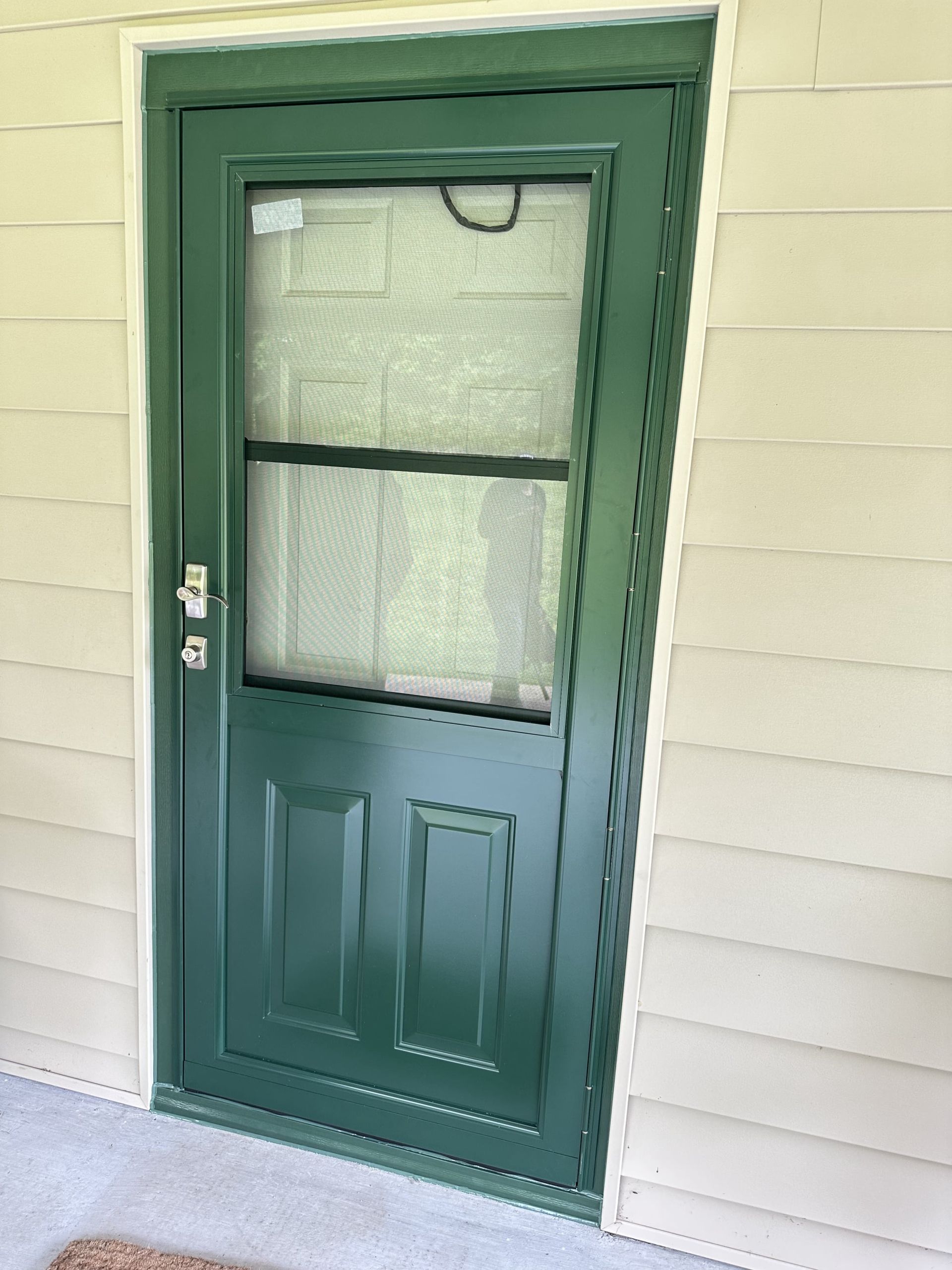 A green door with a window on the side of a house.