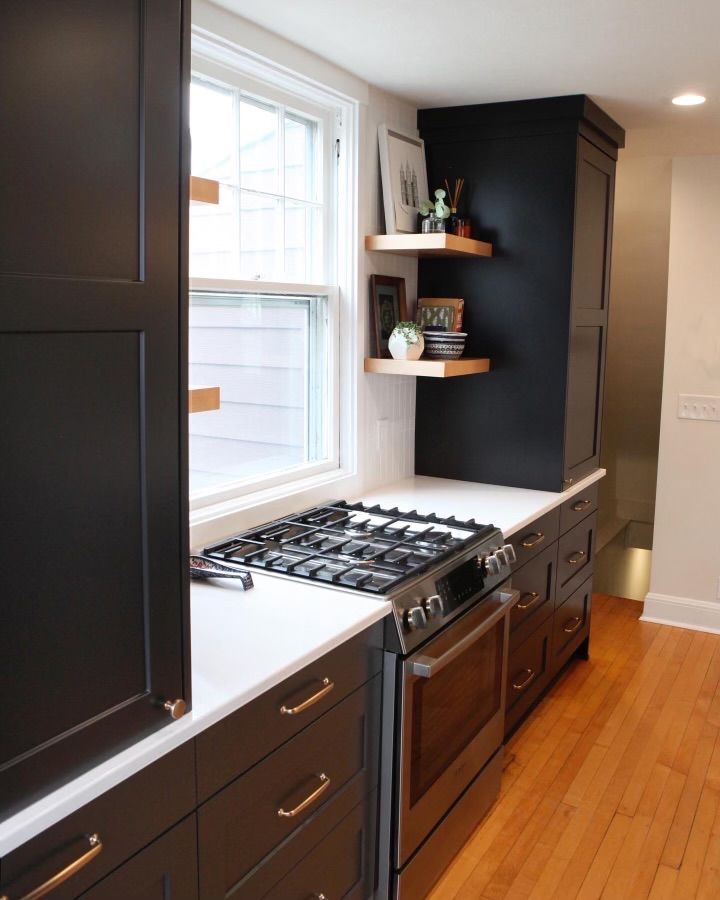 A kitchen with black cabinets and stainless steel appliances