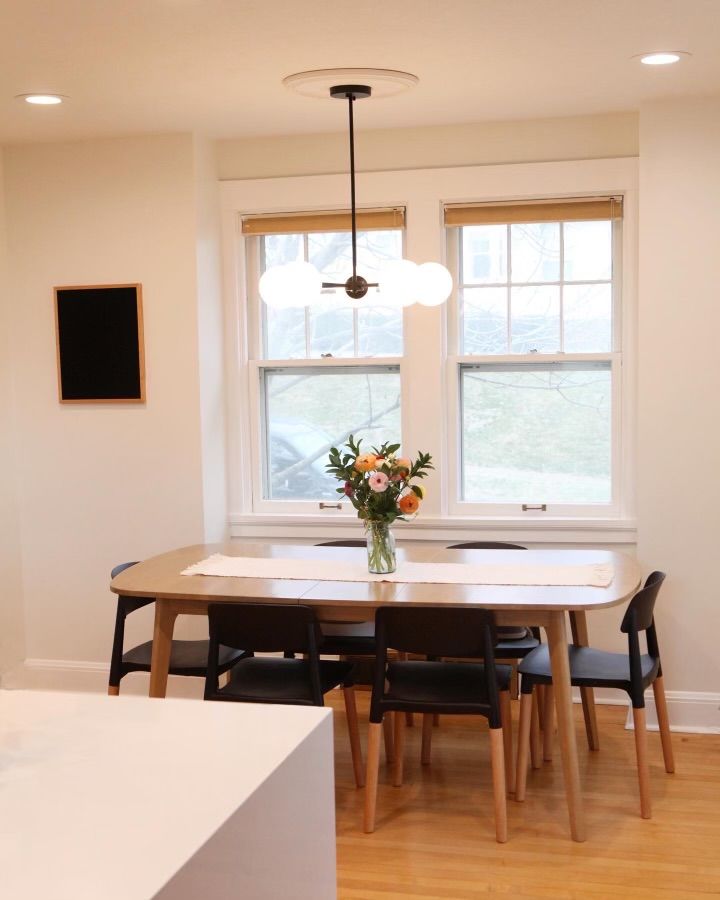 A dining room table with a vase of flowers on it