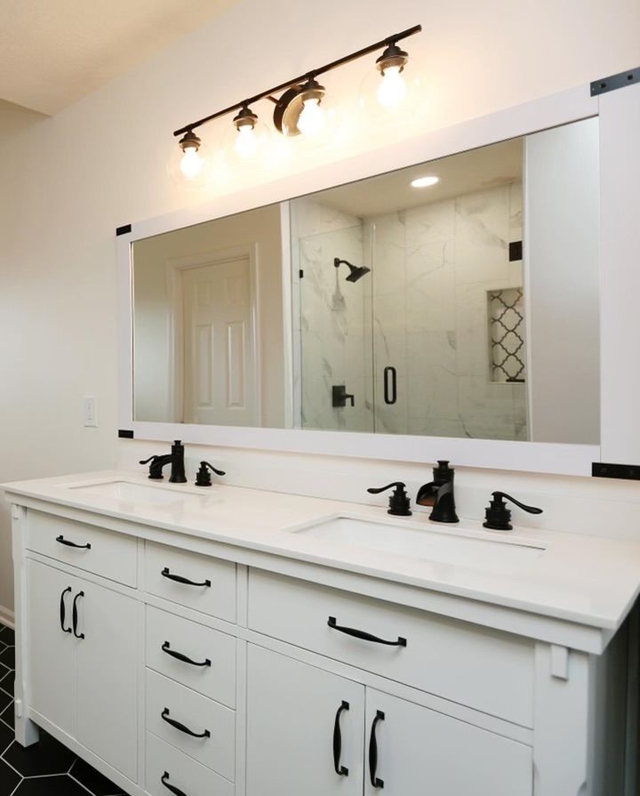 A bathroom with two sinks and a large mirror.