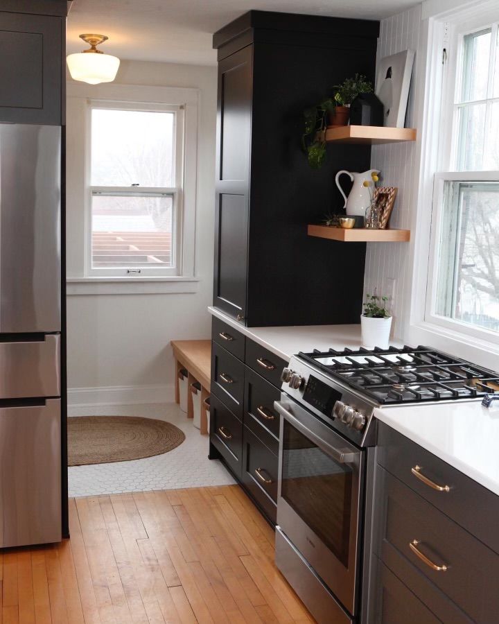 A kitchen with stainless steel appliances and black cabinets