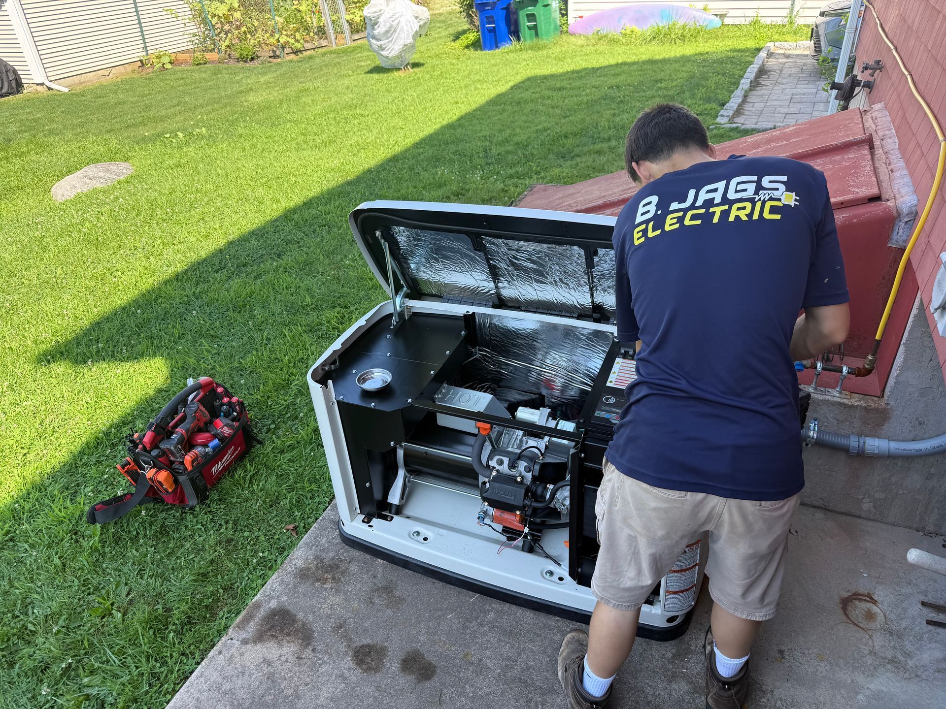 Technician servicing outdoor HVAC unit beside a house, with tools on the lawn.