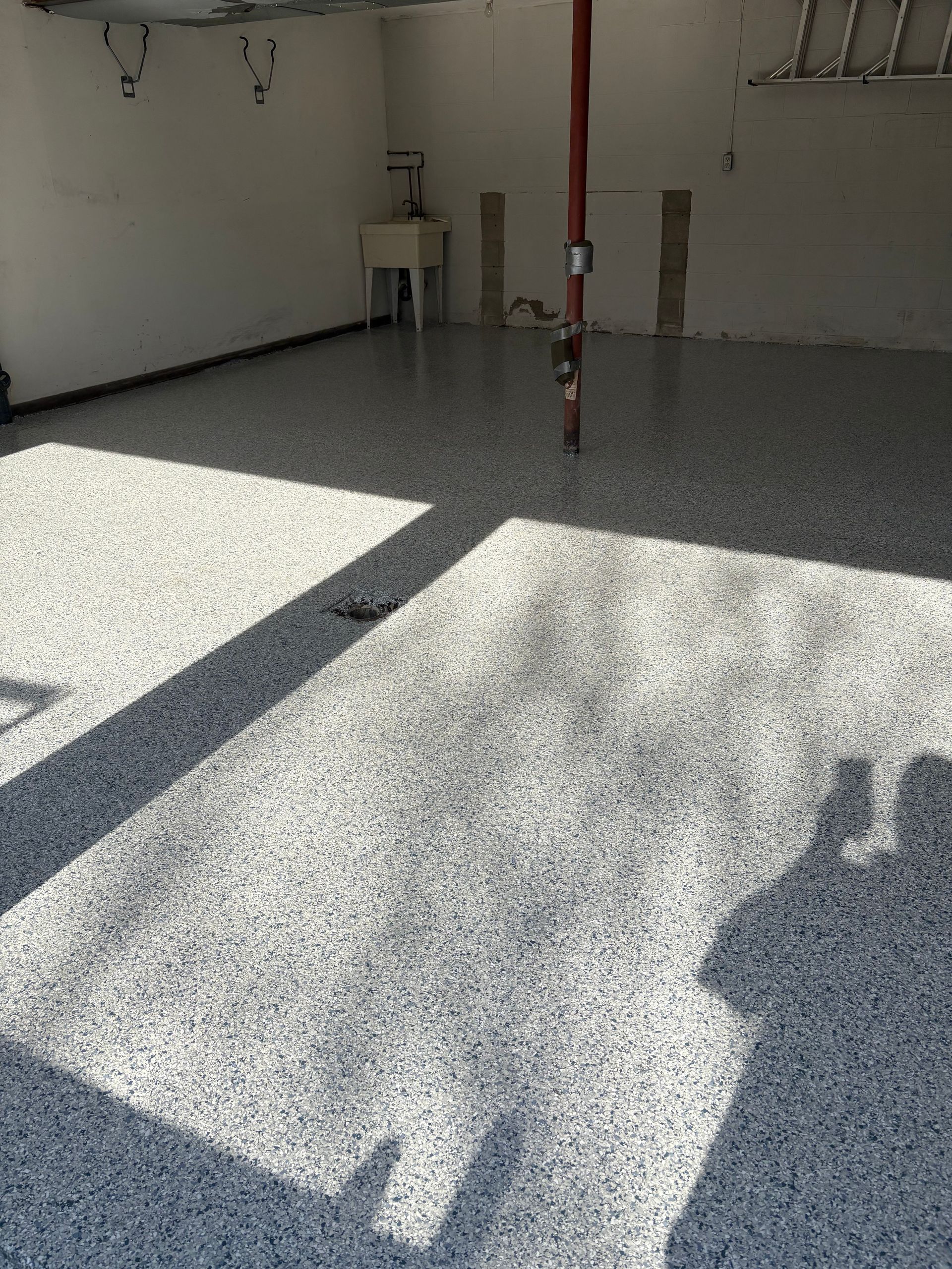 A garage with a shadow of a person on the floor.