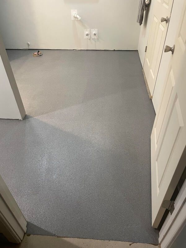 A room with a gray floor and white doors.