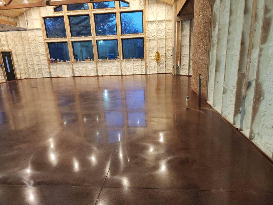 A large room with a shiny concrete floor and a lot of windows.
