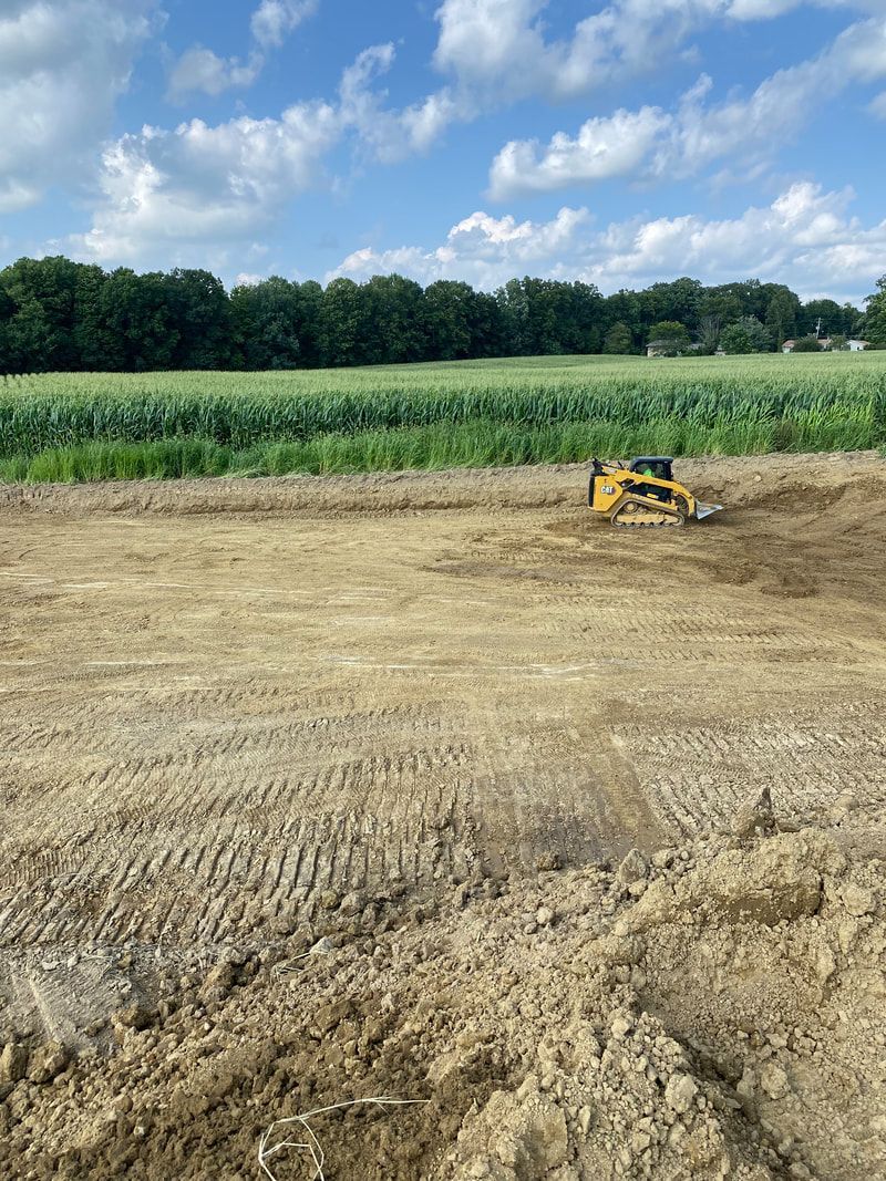A bulldozer is sitting in the middle of a dirt field.