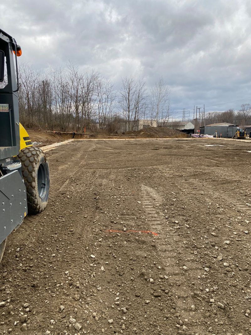A bulldozer is driving through a dirt field.