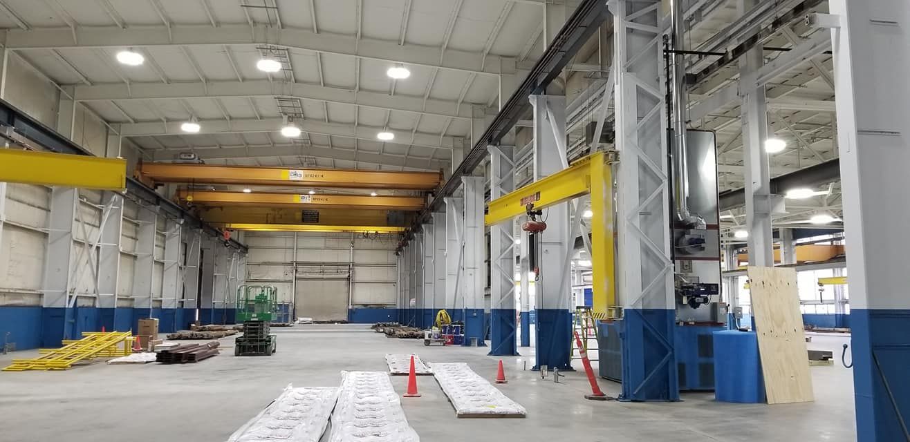 A large warehouse with a crane in the middle of it.