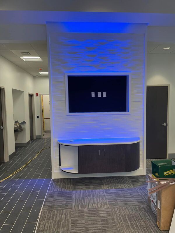 A large flat screen tv is mounted on a wall in a hallway.