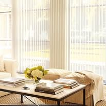 A living room with a couch , coffee table , and books on it.