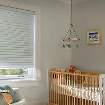 A baby room with a crib , chair , window and blinds.