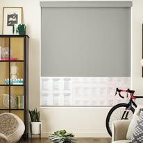 A living room with a bicycle parked in front of a window.