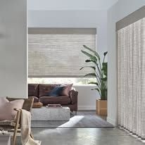 A living room with a couch , chair , table and window with blinds.