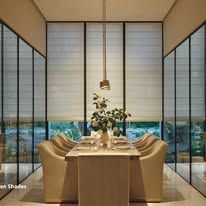 A dining room with a table and chairs and a lot of windows.