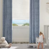 A living room with a couch , table , and window with vertical blinds.