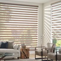 A living room with a couch , chairs , table and blinds.