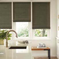 A kitchen with a sink , faucet , and window shades.