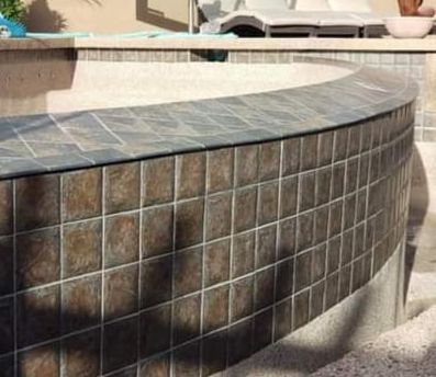 A swimming pool with a curved wall made of tiles.