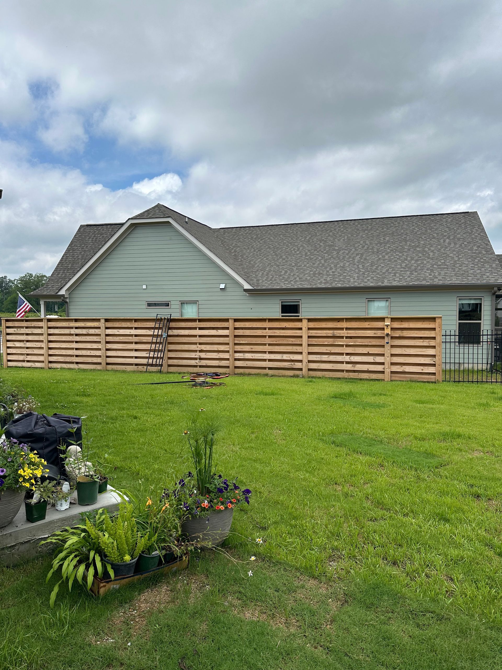 There is a wooden fence in the backyard of a house.