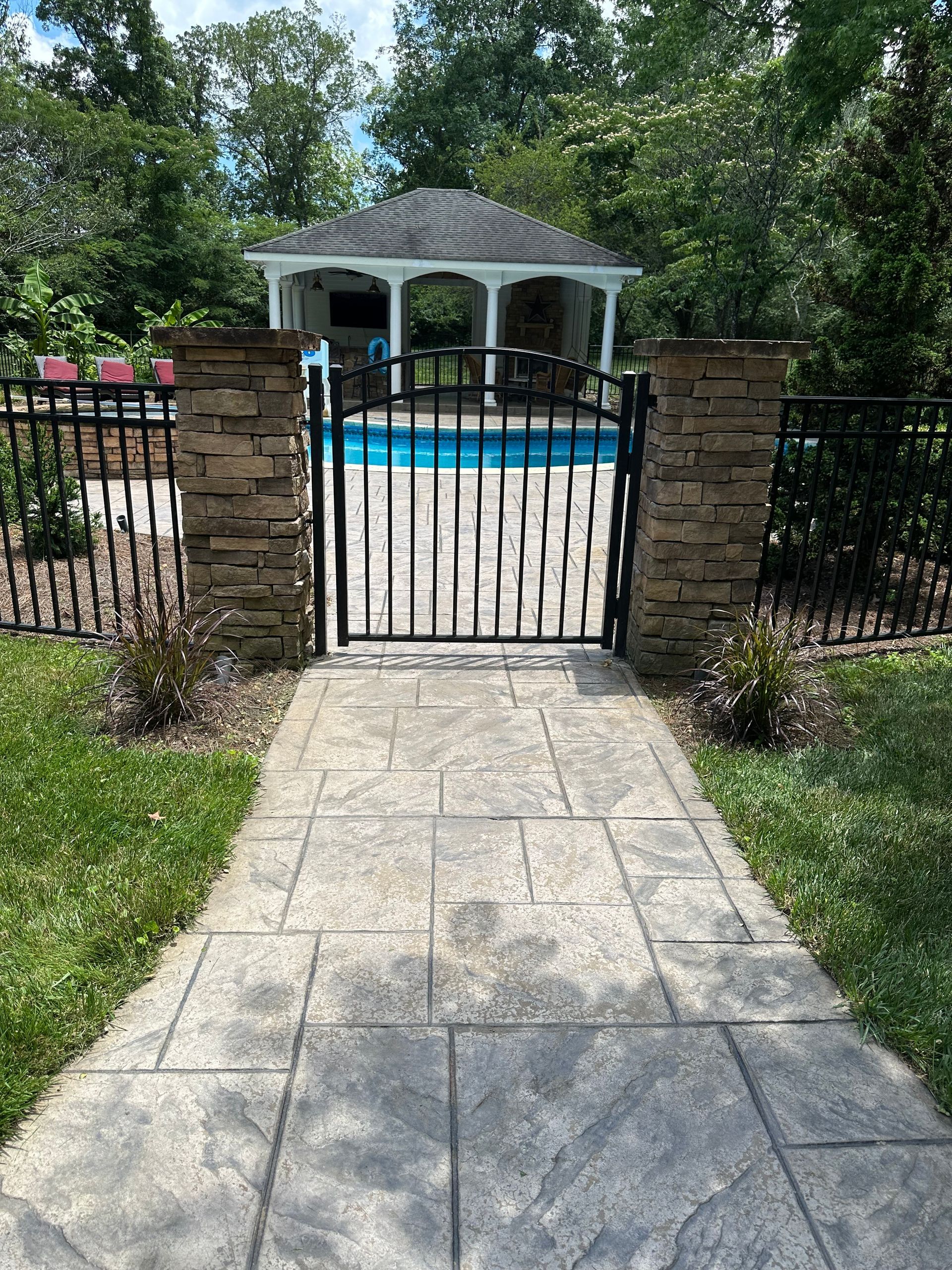 A walkway leading to a gazebo and a swimming pool.