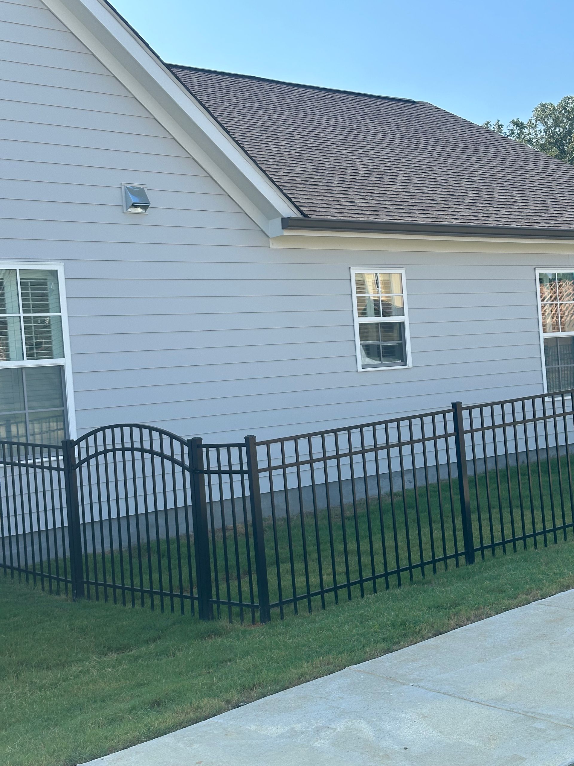 A white house with a black fence in front of it
