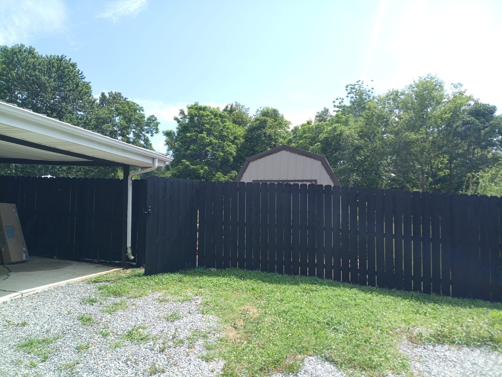 There is a black fence in the backyard of a house.