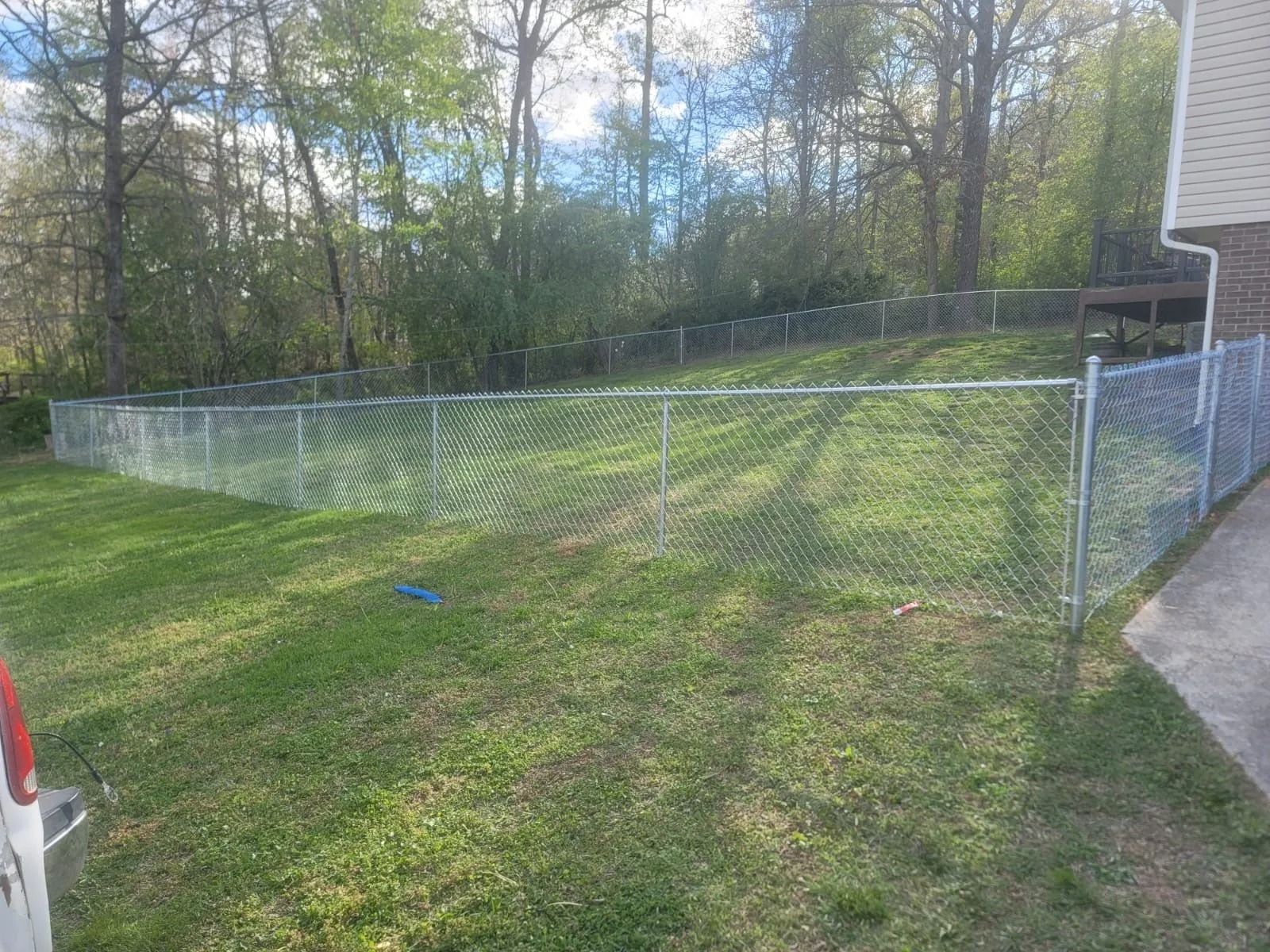 There is a chain link fence in the backyard of a house.