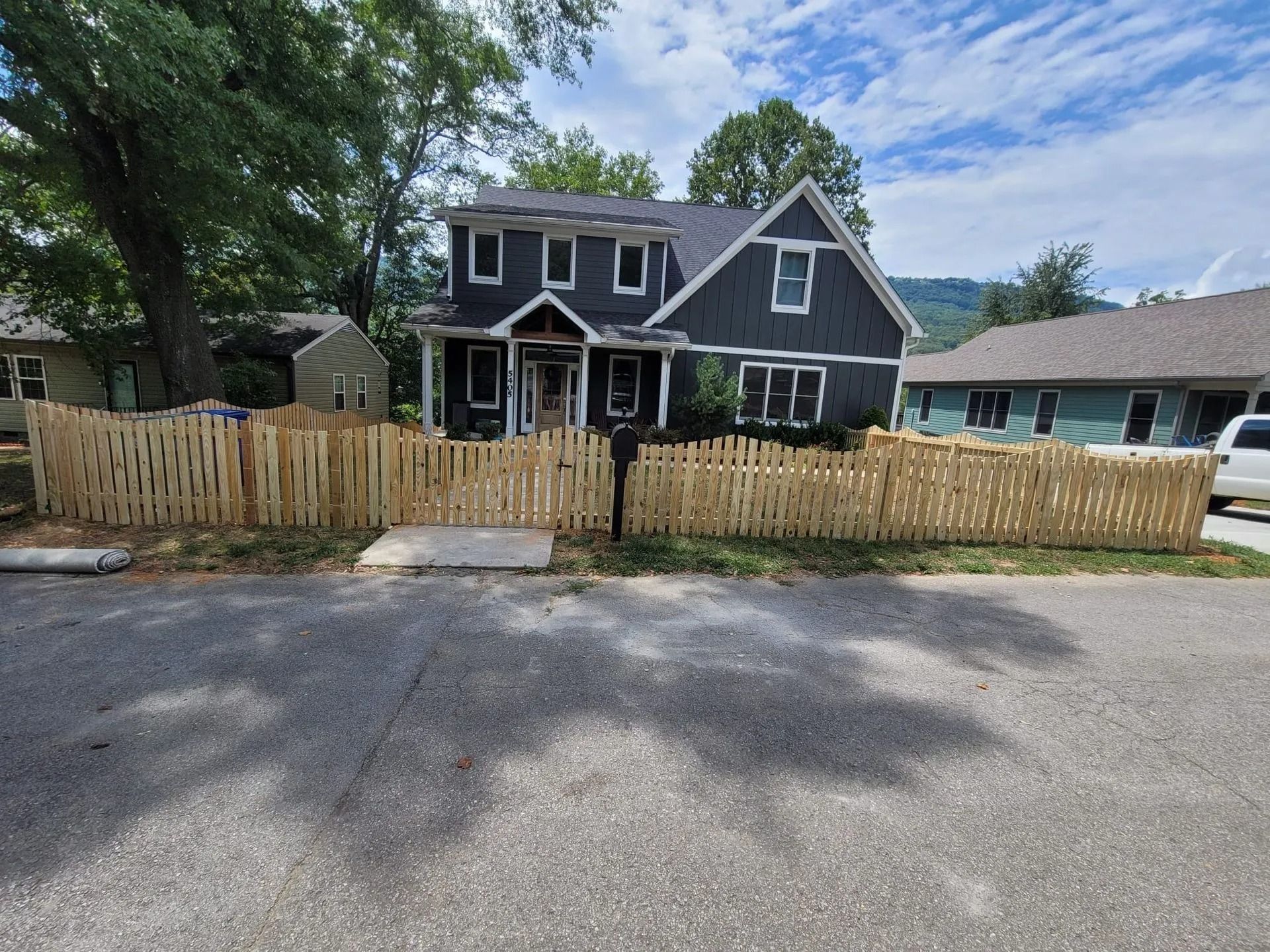 A large house with a wooden fence in front of it.