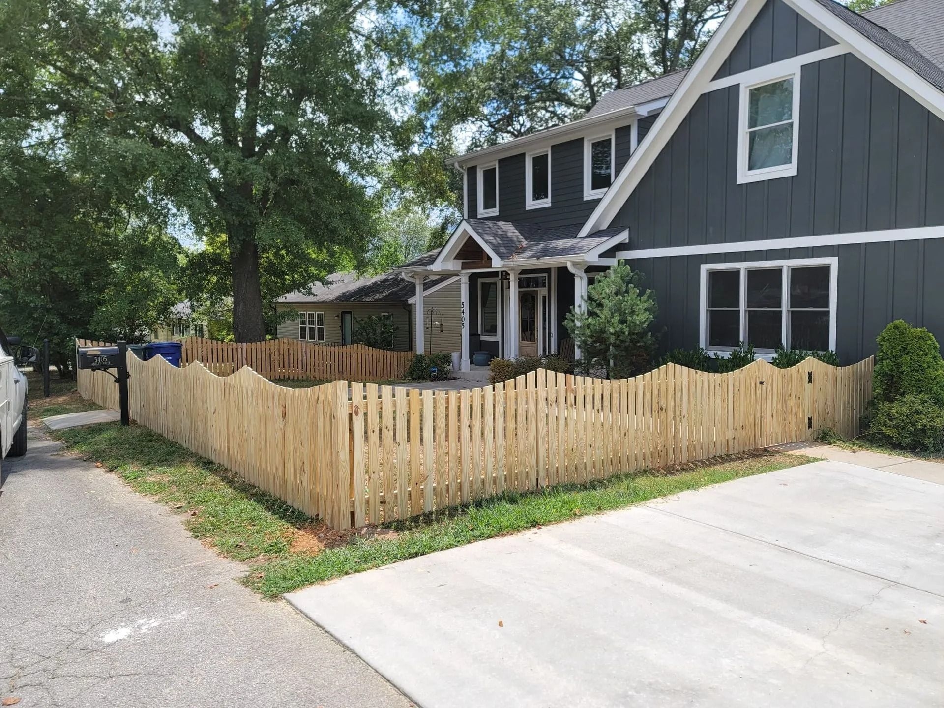 A house with a wooden fence in front of it.