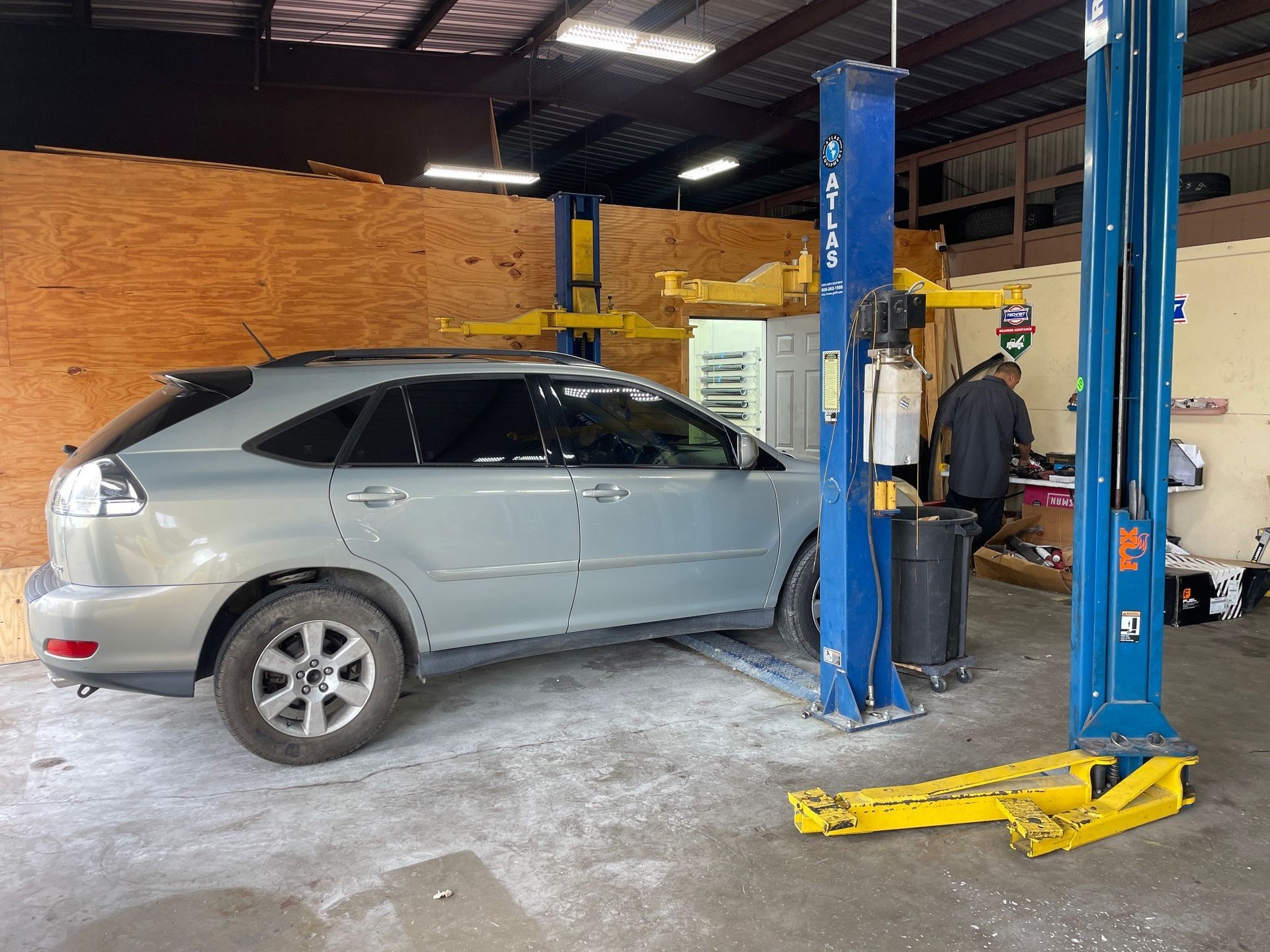 A car is sitting on a lift in a garage.