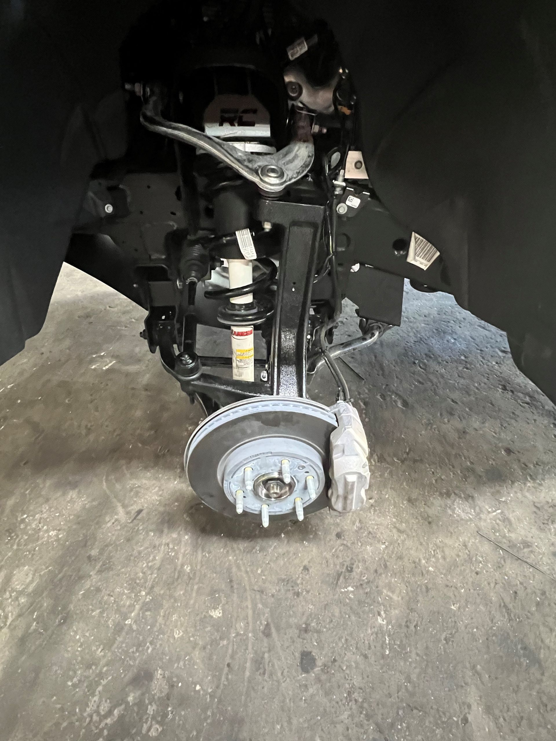 A close up of a car 's suspension and brake system.