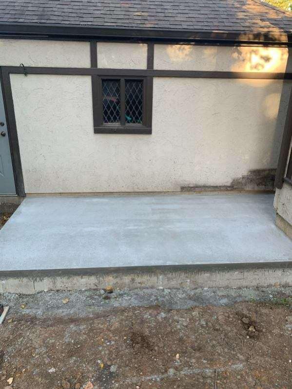 A concrete walkway is being built in front of a house.