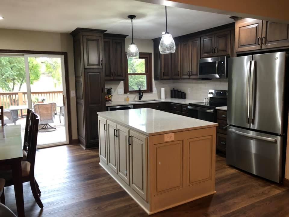 A kitchen with stainless steel appliances and a large island in the middle.