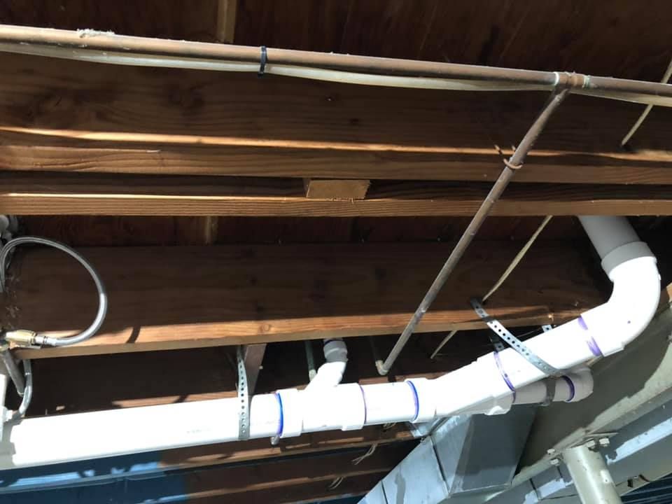 A bunch of pipes are hanging from the ceiling of a building