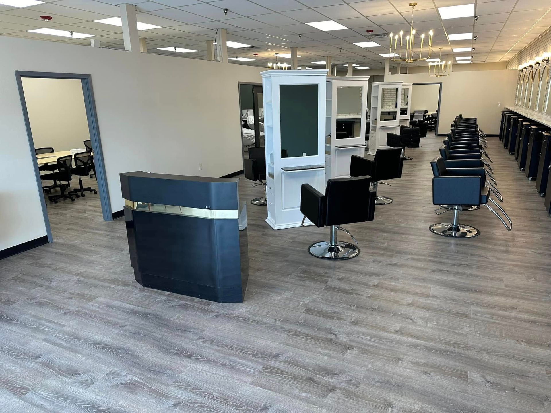 A large salon with a lot of chairs and mirrors.