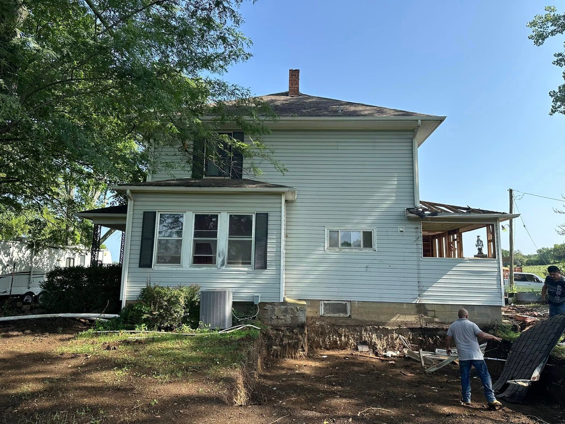 A man is standing in front of a white house that is being moved.