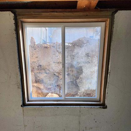 A window in a room with a hole in the wall behind it.
