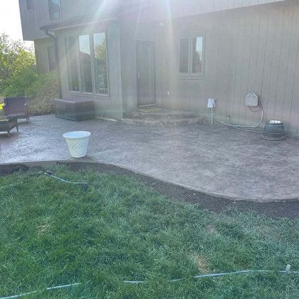 A patio is being built in the backyard of a house.