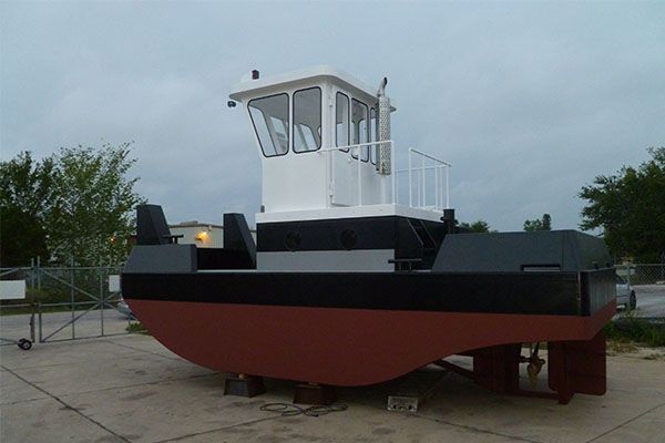 A large red and black boat is sitting on the ground