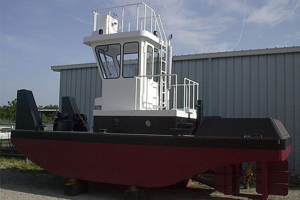 A red and white boat is parked in front of a building.