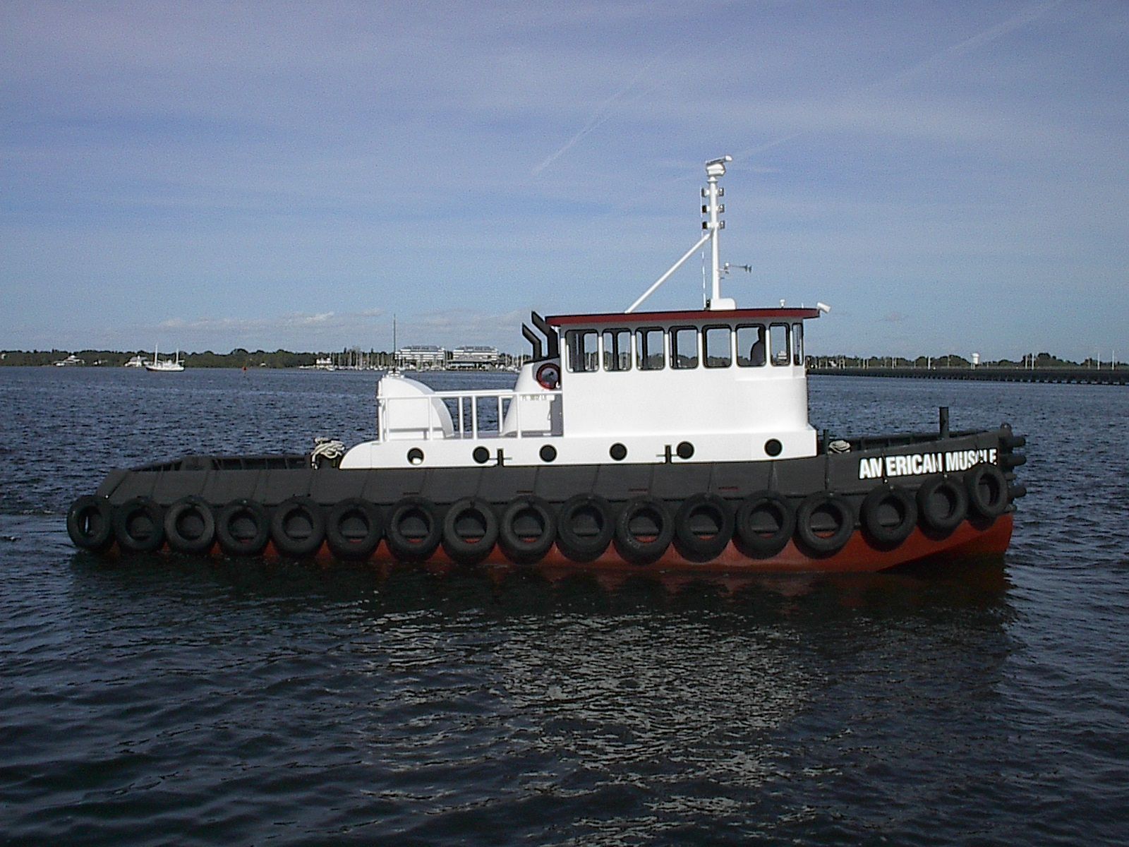 A tug boat with the name mr. emerson on the side