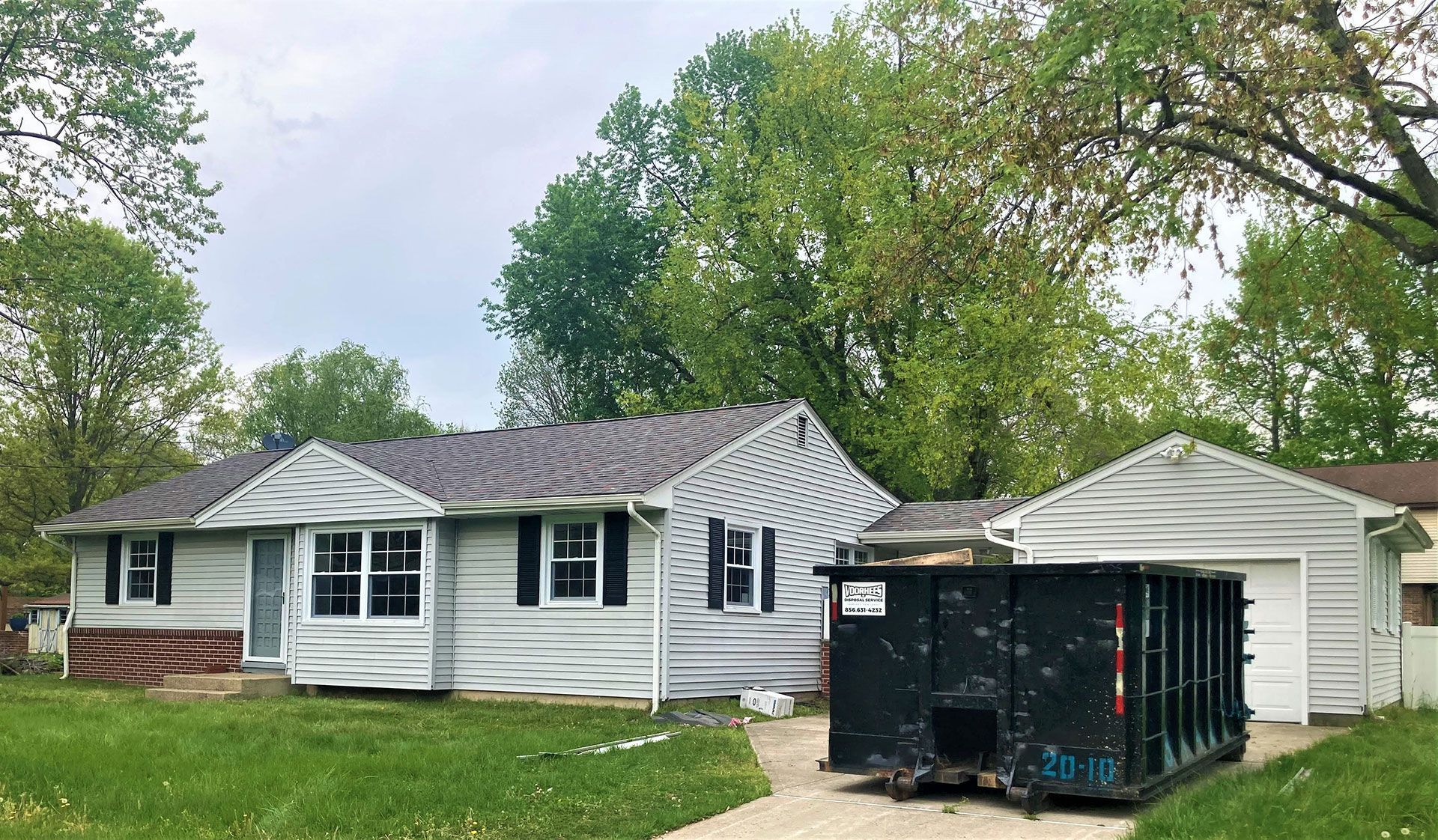 A house with a dumpster in front of it